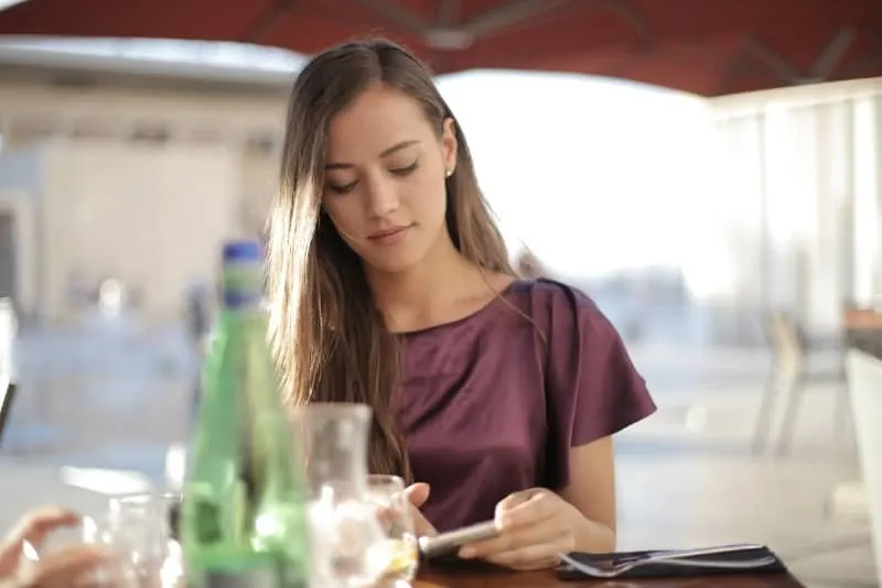 woman in purple top using phone