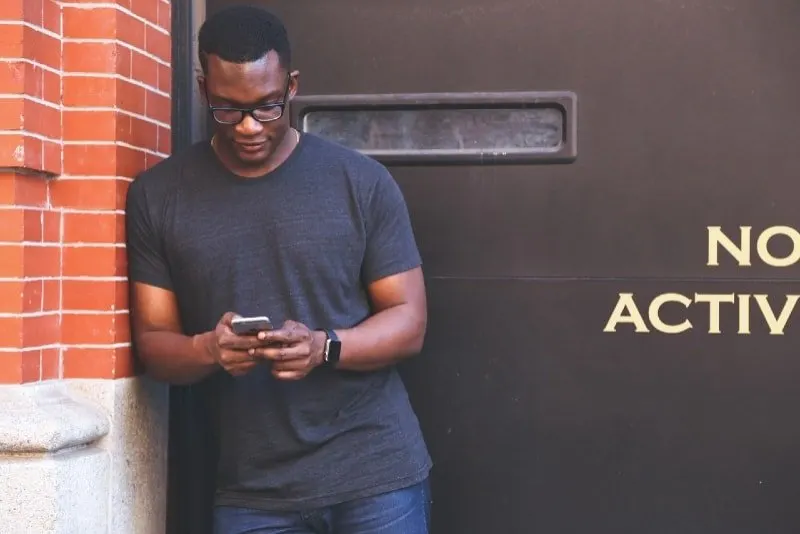 man in gray t-shirt using smartphone