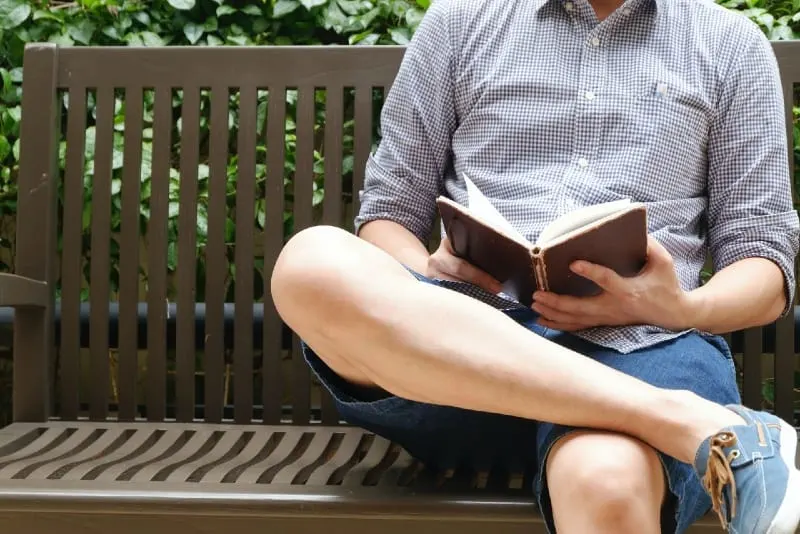 10 signes que votre ex fait semblant d'avoir tourné la page 9 man reading book while sitting on bench