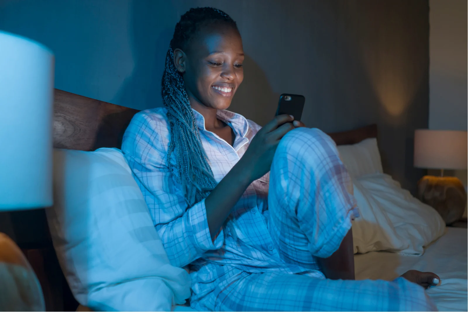 woman sitting in her bed texting man