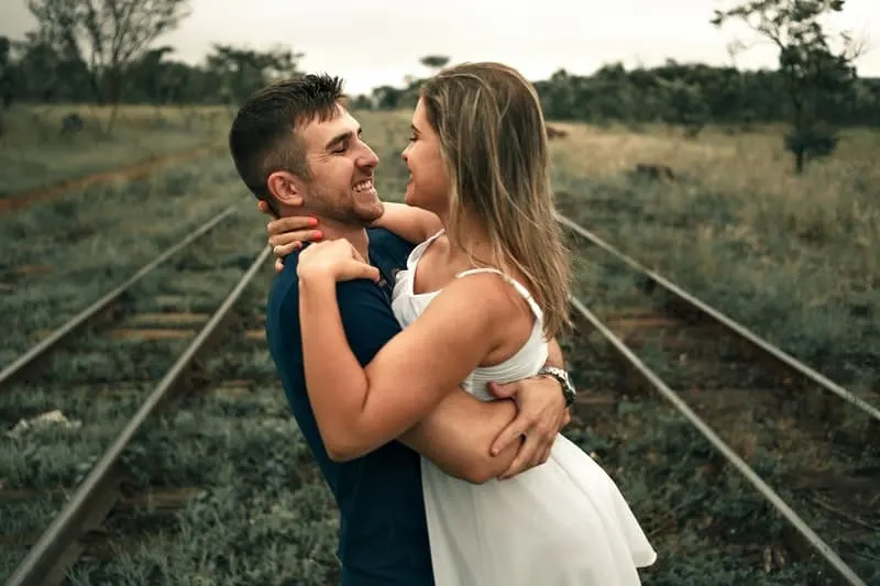 60 des meilleures idées pour complimenter un homme sur sa personnalité 13 man lifting woman in the middle of the railway track
