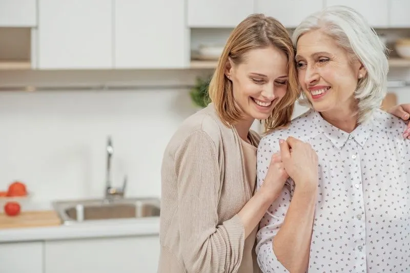 60 des meilleures idées pour complimenter un homme sur sa personnalité 22 woman hugging an older woman inside the kitchen
