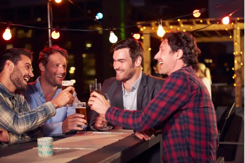 rooftop party of group of men drinking beers during the night