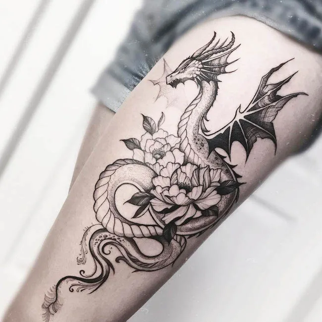 Dragon on the outer thigh by @tattooastrid