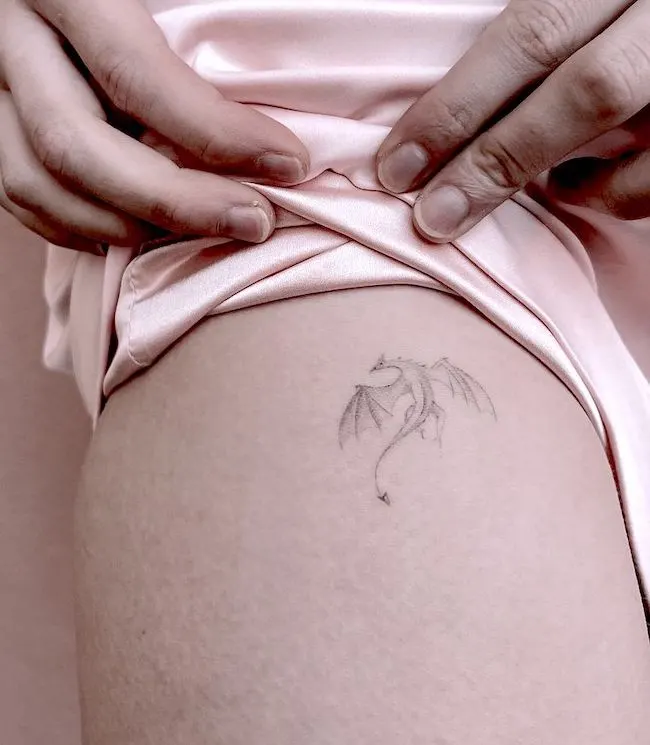 Small dragon thigh tattoo by @trish__ink