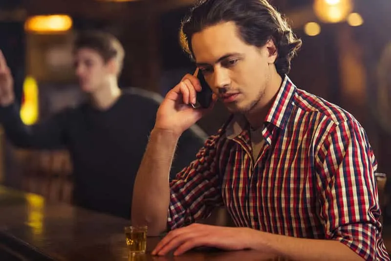 20 signes évidents que votre ex finira par revenir 11 man talking on phone at bar