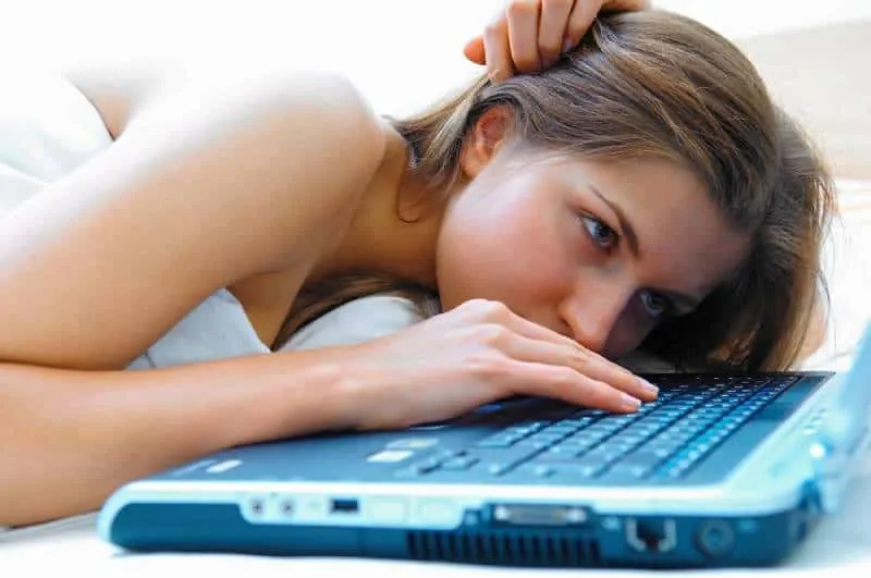 20 signes évidents que votre ex finira par revenir 15 girl lying in bed and typing on laptop