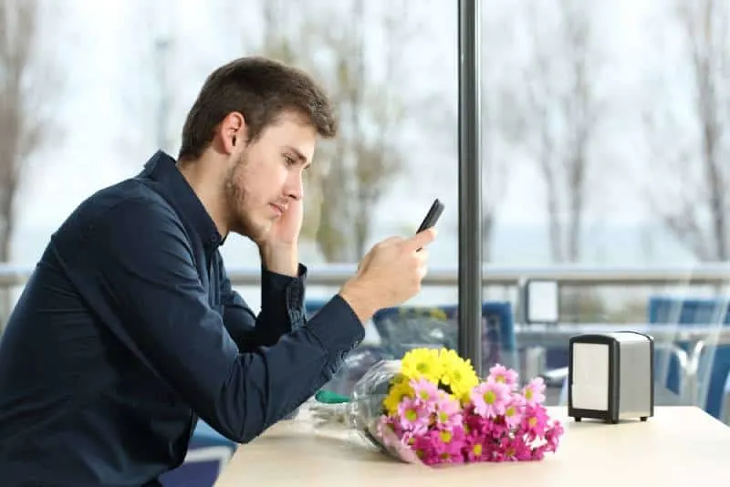 20 signes évidents que votre ex finira par revenir 7 man looking at phone unhappy