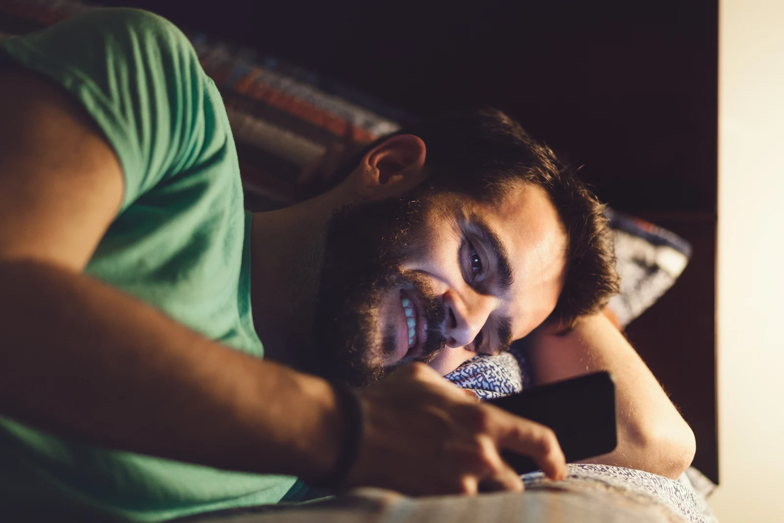 Top 9 des textos pour le faire courir après vous 4 happy man lying in his bed reading messages