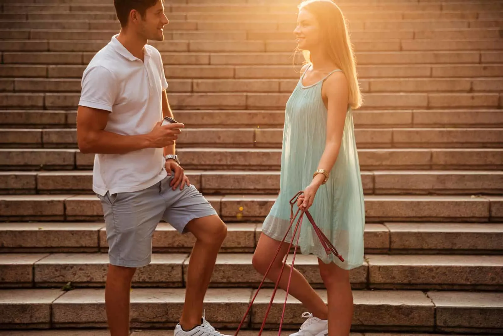 a man and a woman stand on the stairs and talk