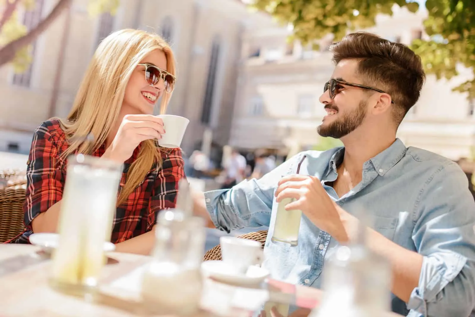 a couple in love sitting outdoors and drinking coffee